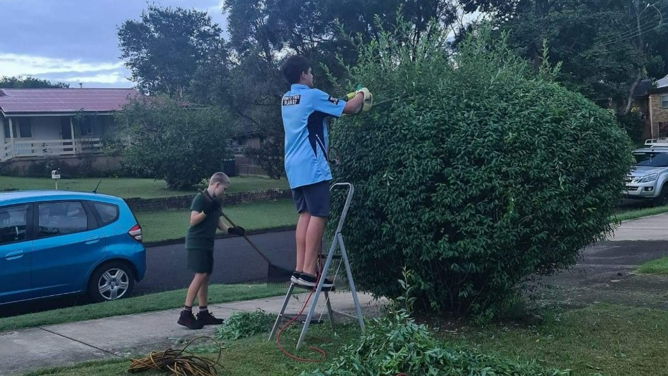 Young men in Australia lend a hand to a neighbour.