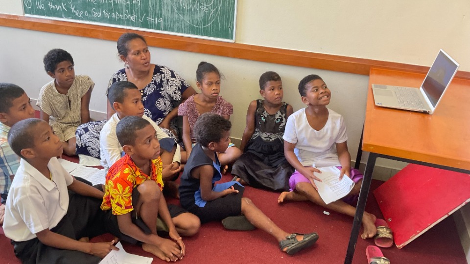 Children in Fiji watch a 