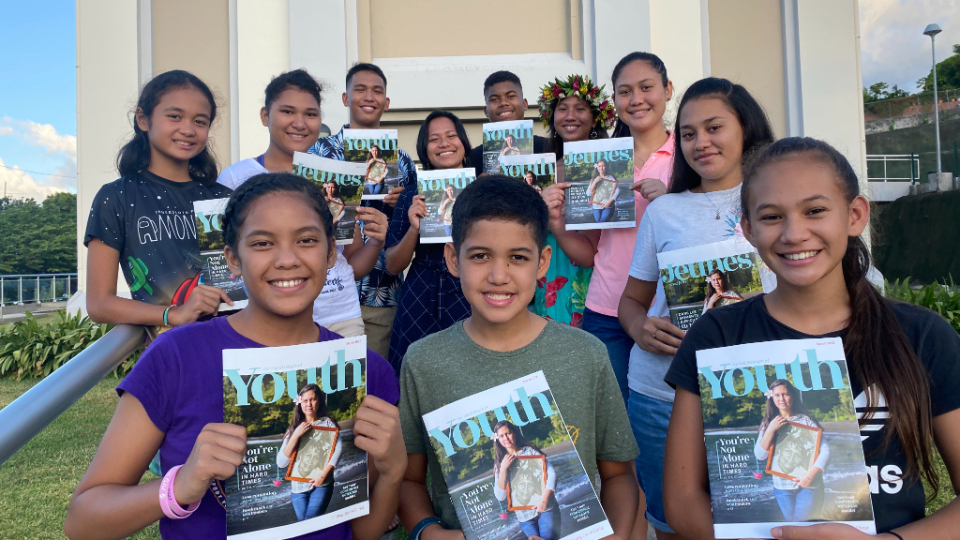 Linahei-(in-pink)-with-her-church-youth-group-after-reading-English-and-French-editions-of-the-For-the-Strength-of-Youth-magazine.--French-Polynesia,-April-2022