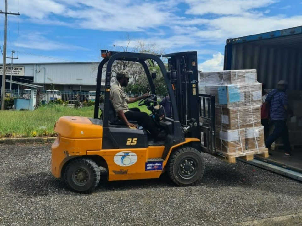 A forklift driver unloads medical equipment donated by The Church of Jesus Christ of Latter-day Saints and partners. Papua New Guinea. March 2022.